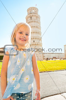 Portrait of baby girl in front of leaning tower of pisa, tuscany