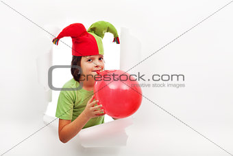 Happy boy with funny hat celebrating with a balloon