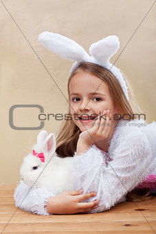 Happy girl in bunny costume holding her white rabbit