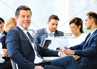 Happy businessman using laptop in business building
