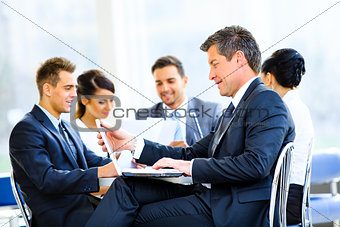 Happy businessman using laptop in business building
