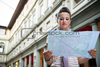 Young woman looking in map near uffizi gallery in florence, ital