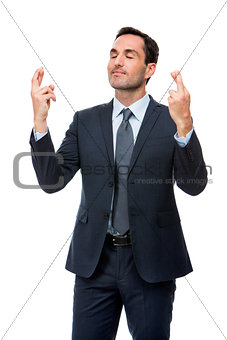 businessman with eyes closed and fingers crossed