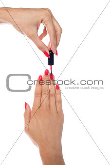 Woman applying red nail polish