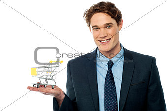 Businessman presenting shopping cart