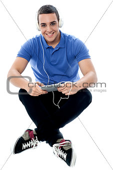 Young guy enjoying music and using tablet pc