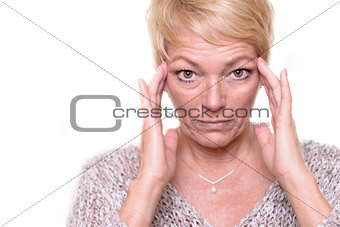 Attractive senior blond woman checking her complexion