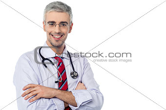 Smiling aged physician, arms crossed