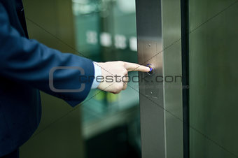 Hand pressing elevator button