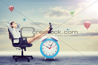 Woman in jacket and skirt sitting on chair. Background of clouds