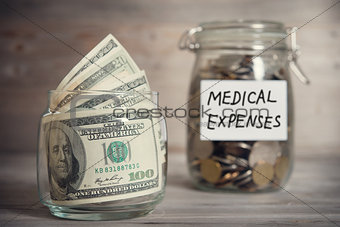 Dollars and coins in jar with medical expenses label