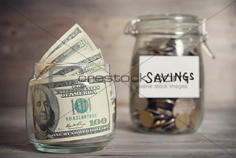Dollars and coins in jar with saving label