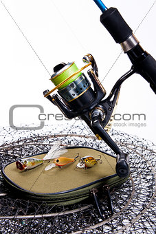 Fishing rod and reel with bag for baits on white.