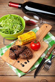 Steak with grilled corn, salad and red wine
