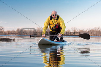 Senior male on stand up paddling (SUP) board