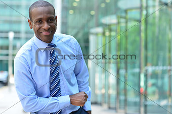 Corporate man poses casually at outdoor