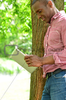 Smiling man using tablet pc in the park