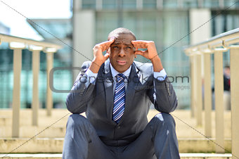 Depressed businessman sitting at outdoors