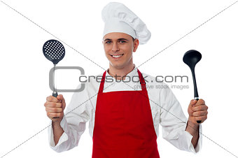 Male chef holding kitchen essentials