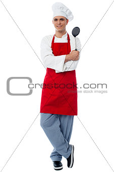 Young chef posing in style with kitchen utensils