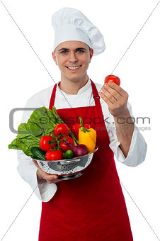 Male chef holding a fresh vegetables