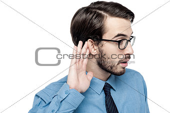 Corporate man listening with hand on ear