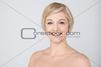 Topless woman smiling over grey