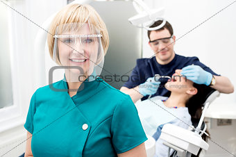 Male dentist with patient, in clinic.