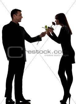 one couple man offering rose flower and woman smelling silhouett