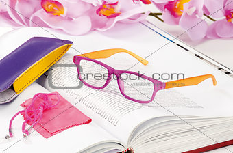 reading glasses endorsed on a book at home