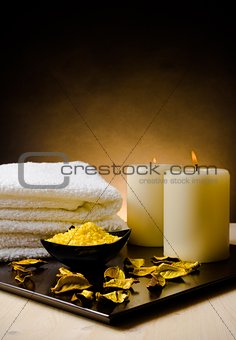 Spa massage border background with towel stacked, perfumed leaves, candle and sea salt