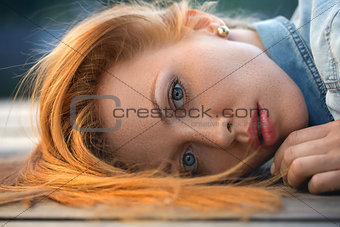 Fashion portrait of strict red-haired girl, close up.