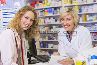Pharmacist and costumer looking at camera