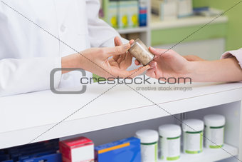 Pharmacist and costumer holding medicine jar