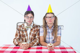 Unsmiling geeky hipsters celebrating birthday