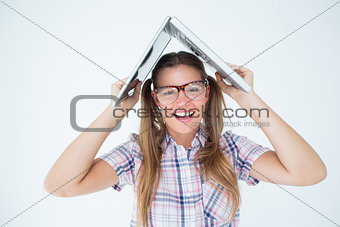 Geeky hipster holding her laptop over her head