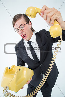 Geeky businessman shouting and hanging up the telephone