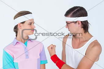 Geeky hipster showing fist to his girlfriend