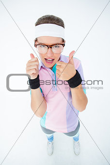 Smiling geeky hipster looking at camera thumbs up