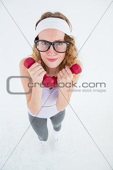 Geeky hipster lifting dumbbells