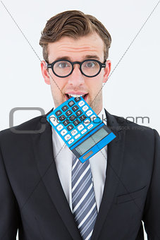 Geeky businessman biting calculator