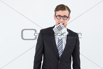 Geeky businessman biting calculator