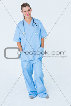 Happy nurse smiling at camera with hands in pockets
