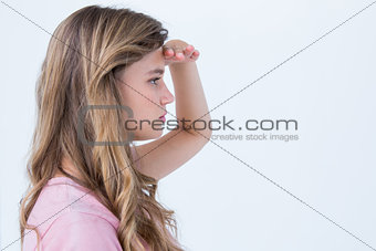 Pretty blonde looking the horizon with hand on forehead