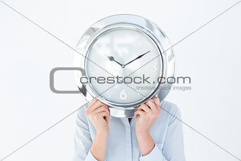 Businesswoman in suit holding a clock