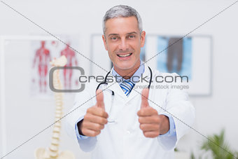 Happy doctor looking at camera with thumbs up