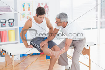 Doctor examining his patient knee