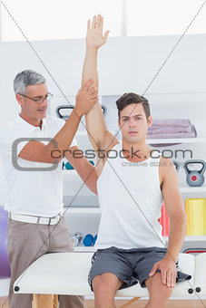Doctor raising a young man arm