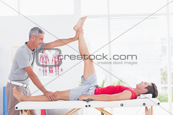 Physiotherapist doing leg stretching to his patient