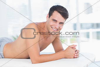 Smiling patient lying on massage table and looking at camera